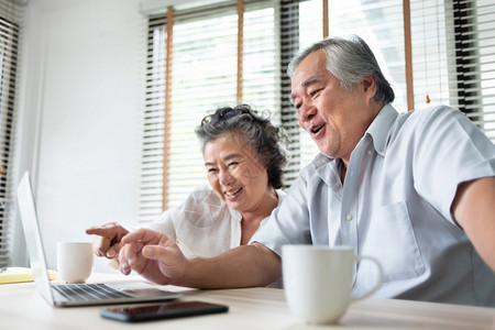 祖父母放松的亚洲老年夫妇通过视频电话和在笔记本脑上与家人交谈快乐笑日本长老男女在家享受互联网技术生活风格乐趣等游戏愉快人图片