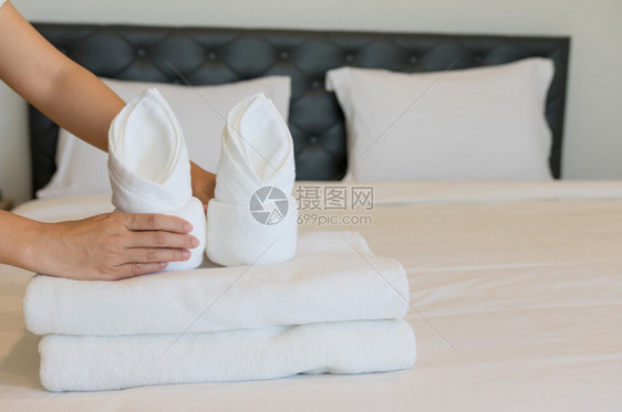 折叠现代的保持年轻旅馆女青把软毛巾床铺和放在一家旅馆清洁工身上放在床干净的白毯子早卧室有枕头软毛巾图片
