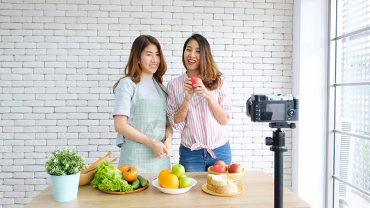 人们两位年轻的青女食物博客在录制视频时交谈与快乐刻vlog概念人与科技通讯等术营养图片