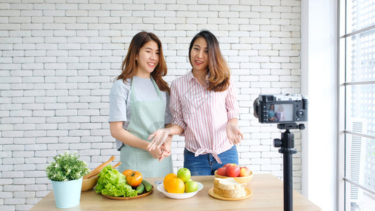 新鲜两位年轻的青女食物博客在录制视频时交谈与快乐刻vlog概念人与科技通讯等工作流背景图片