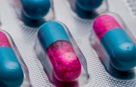 预防粉色的蓝胶囊有选择焦点在侧药丸中颗粒带的粉红色胶囊在白底的泡水袋中浸药品剂量表和包装反风药盒图片