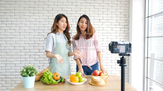 两位年轻的青女食物博客在录制视频时交谈与快乐刻vlog概念人与科技通讯等居住服用沙拉图片