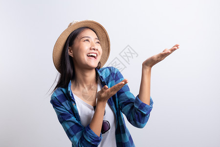 吃惊时尚亚洲女孩穿着普拉德衬衫草帽太阳眼镜复制空间夏日概念带着白背景的笑容和微着亚洲女孩穿上普莱德衬衫展示图片