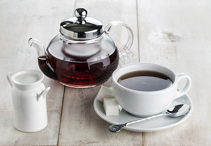 草本玻璃茶壶热红杯和木桌上的牛奶壶玻璃水热红茶杯和木桌上的牛奶壶文化传统的图片