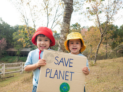 两个拿着拯救地球海报的小女孩兄弟姐妹展示了抗议森林塑料污染的标语世界环境日零废物的概念节省行星天图片