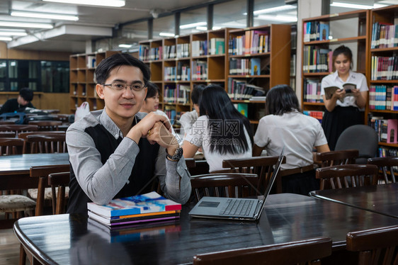 学习笔记本电脑为了在图书馆和课堂上回答问题时将大学教育概念的亚洲师肖像给大学生团体以解答这个问题大学教育概念图片