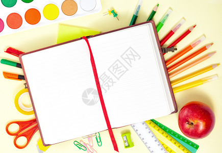 黄色的目回到学校概念空白笔记本彩色壁纸脚红苹果剪刀黄色背景上的绘画盘教育图片