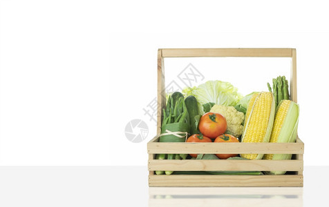 营养灰色的各种新鲜有机蔬菜在灰色桌顶的有白墙背景木制篮子上水果图片