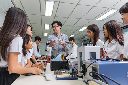 亚洲教师向在实验室教里展示古生物的大学群体教授育概念亚洲师给这些学生提供教课程亚洲人身体的笔记本电脑图片