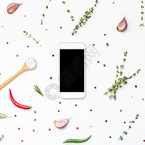 平板躺着迷迭香白色背景的智能手机模拟假冒空白文本间带绿色草药和香料菜单设计食品博客谱烹饪手册或配有素材的送餐程序图片