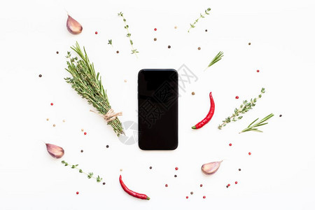 空白的迷迭香勺子色背景的智能手机模拟假冒空白文本间带绿色草药和香料菜单设计食品博客谱烹饪手册或配有素材的送餐程序图片