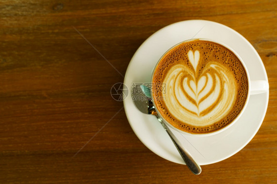 浓咖啡热拿铁和艺术牛奶泡沫杯放在最顶端的木桌前茶杯上在咖啡馆店吃早餐在商业工作构想期间甜的卡布奇诺图片