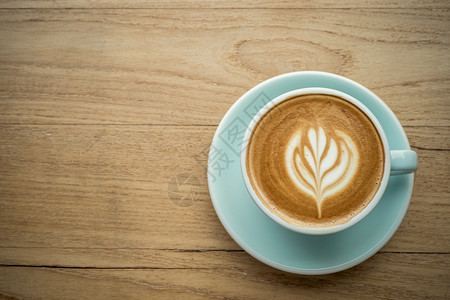 复古的饮料休息热咖啡拿铁和艺术牛奶泡沫杯放在最顶端的木桌前茶杯上在咖啡馆店吃早餐在商业工作构想期间图片