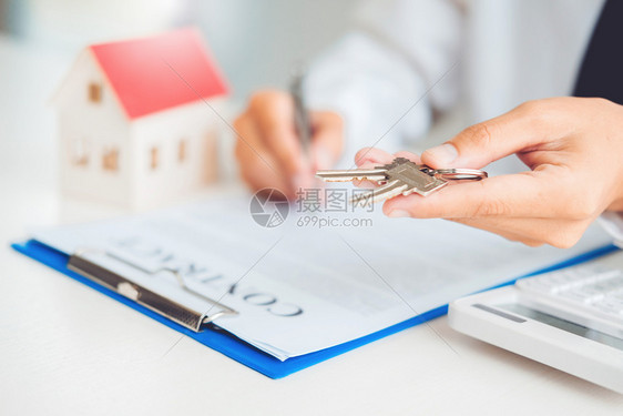 商业房主买方向客户提供房钥匙和签署协议合同的销售代理商保险住房概念图片