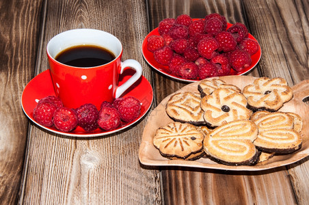 在旧木制桌子顶端的红莓咖啡杯和饼干饮食早晨新鲜图片