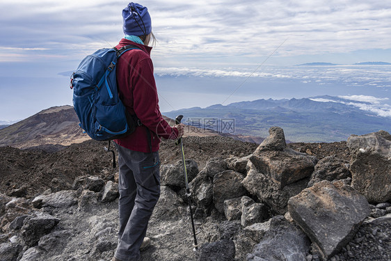 顶峰装备齐全的高级登山者站在岩石高山顶上风景优美攀登背包图片