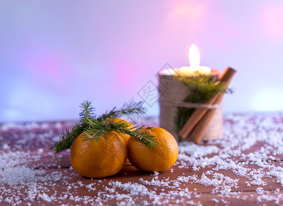 在雪瀑下积覆盖的表面做个普通人和蜡烛手工制作的柑橘季节图片