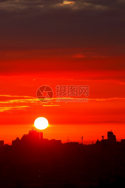 颜色地标清晨阳光明亮的太以红光照射天空升至沉睡城市垂直图象房屋的轮盘上方复制空间清晨在城市房屋垂直图象的轮椅上一个明亮的红色太阳图片