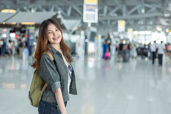 年轻的假期步行快乐亚洲美丽女在机场候站旅行并携带手提箱乘客有人群背景乘客人与生活方式概念环球之旅主题为欢乐的旅游女孩图片
