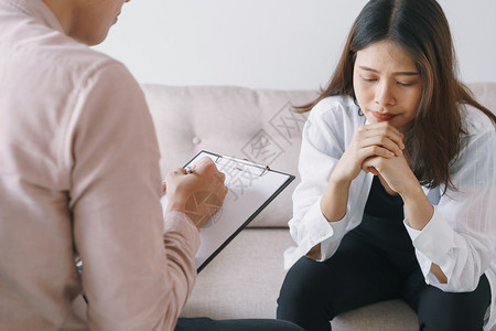 精神科医生专业的帮助接受男心理医生检查咨询的亚裔女病人以及由医生在临床精神病学概念中进行心理治疗的亚洲女病人图片