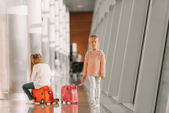 在大国际机场的可爱小女孩准备度假舒适小女孩在机场玩得开心坐在行李箱上等登机等待登机的好女孩手提箱飞机场图片