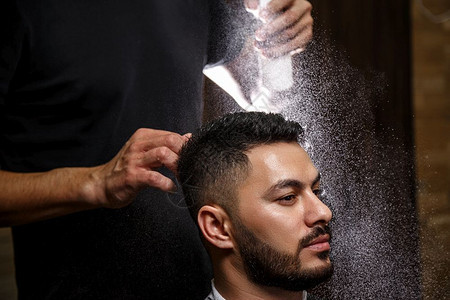 技能一种身着黑衣服的理发师正在给坐理发店扶椅上的时髦黑头发男子做型设计阳刚之气图片