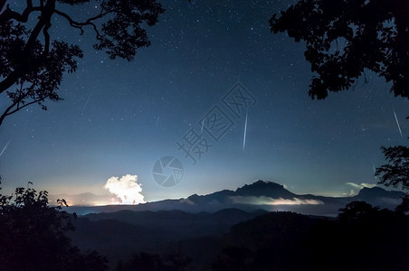 夜空中山脉上的流星雨图片