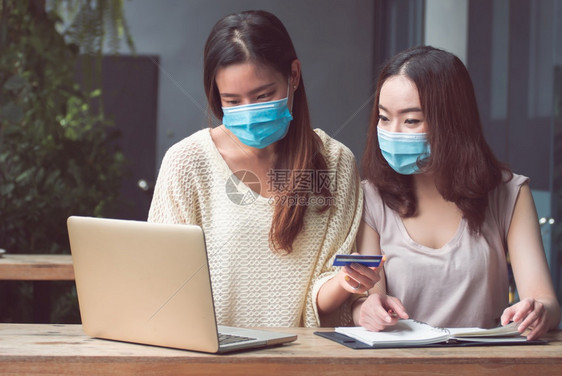 制作在线的女士两名持有空白信用卡的亚裔妇女为在家中网上购物付费而买家庭卫生商业和金融概念构想图片