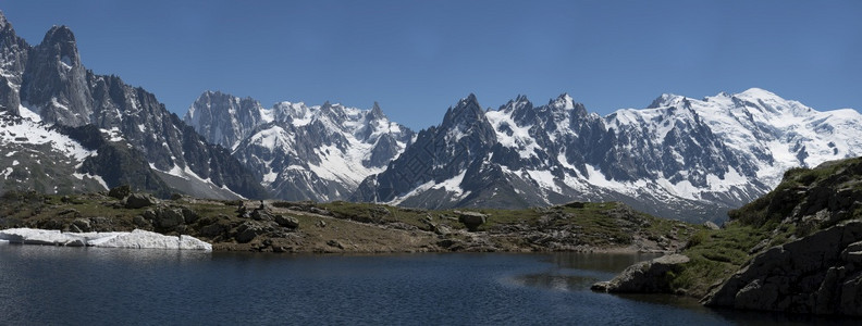 安宁攀登人们在山上的一个湖边徒步旅行其背景是冰川和高度图片