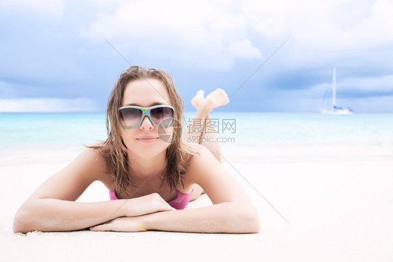 年轻女子在海滩上日光浴图片
