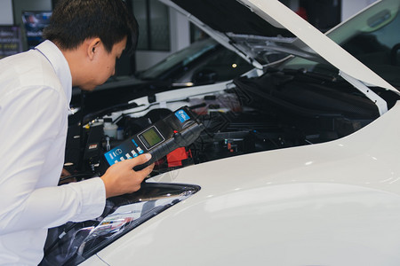 泰国工厂人们业维修机引擎保养的电池容量测试器伏特计服务维护设备装有充电能力测试仪Voltmeters的检查人员图片