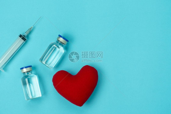 工作爱项目表格顶视图显示有心形冠状背景概念疫苗瓶和蓝纸上的Syringe的医用配科罗纳医疗辅助剂以及使用治疗病人的医生专用物品图片