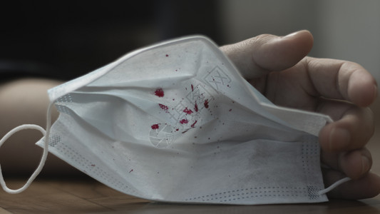 亚洲人污染一名男子手里握着红色血迹中的医疗绷带面罩危险致命疾用血液咳嗽的科罗纳流行感白色的图片