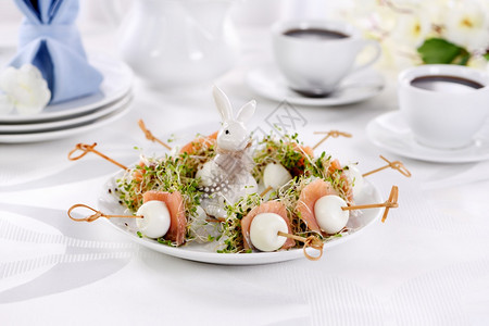 健康开胃鸡蛋塞满了阿尔法芽和一片鲑鱼放在为复活节桌服务的木制烤肉盘上晚餐早图片