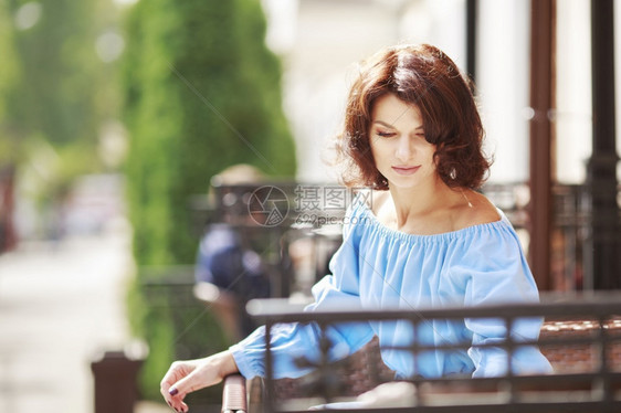 街道手机坐着在市咖啡厅的桌子上美女外出肖像穿浅蓝色礼服和勃根底紧身裤的漂亮女孩浪漫肖像图片