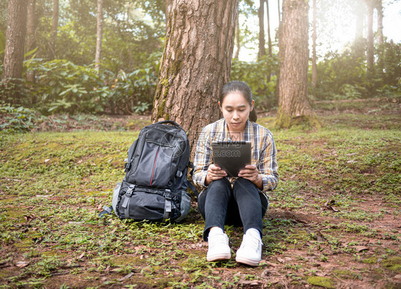 屏幕青年妇女旅行者搜索全球定位系统坐标按平板个人电脑在夏季假期日间自然足迹上标有色人次户外亚洲图片