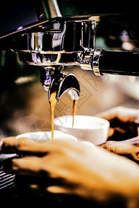 优质的自助餐厅热浓缩咖啡机冲泡倒入店的玻璃杯中浓缩咖啡从机中倒出图片