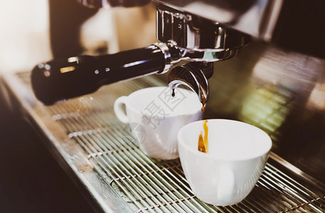 浓缩咖啡机冲泡倒入店的玻璃杯中浓缩咖啡从机中倒出饮料进入可口图片