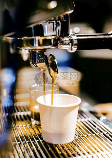 咖啡师饮料浓缩机冲泡倒入店的玻璃杯中浓缩咖啡从机中倒出早晨图片