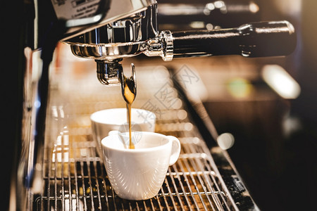 饮料浓缩咖啡机冲泡倒入店的玻璃杯中浓缩咖啡从机中倒出意大利温暖的图片