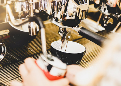 浓咖啡餐厅酿造缩咖啡机冲泡倒入店的玻璃杯中浓缩咖啡从机中倒出图片