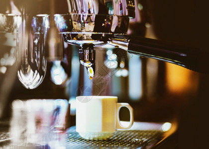 卡布奇诺浓缩咖啡机冲泡倒入店的玻璃杯中浓缩咖啡从机中倒出杯子图片