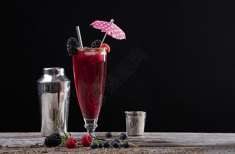冰沙果味茶点以黑莓和摇晃器装饰的木制基地上玻璃杯中果子鸡尾酒图片