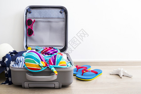 行李箱中华的彩色比基尼和度假用品图片