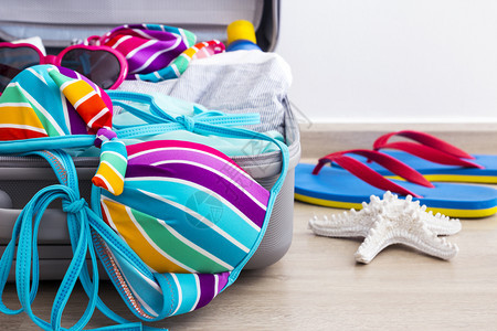 行李箱中华的彩色比基尼和度假用品图片