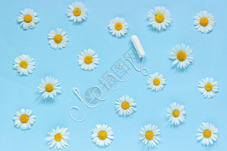 布局一次新鲜女卫生棉条环绕着蓝底的香菊花在月经周期间女和青少年的卫生健康从白线上女卫生棉条和蓝底的茶杯平淡单词CLENEANFl图片