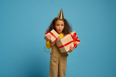 火人们带红丝的生日礼物盒蓝背景的漂亮女孩得到一个惊喜活动庆祝有趣的小女孩在帽子中拿着生日礼物盒Y我孩子图片