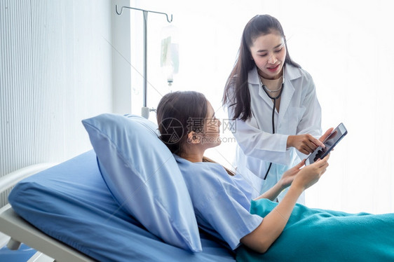 医生用平板电脑向年轻女患者讲解病情图片