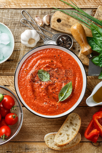 钟桌子传统西班牙冷番茄汤新鲜生蔬菜和烹饪素材在木制桌顶上方的餐桌碗图片