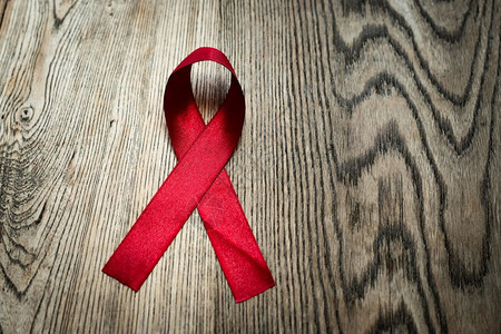 AIDS认识信号红色丝带防治艾滋病在木制桌上的标志别庆典图片